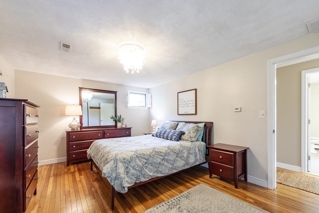 63 Maple Ridge Road Reading, MA 01867 - Photo 24 of 41 a bedroom with a bed and wooden floor