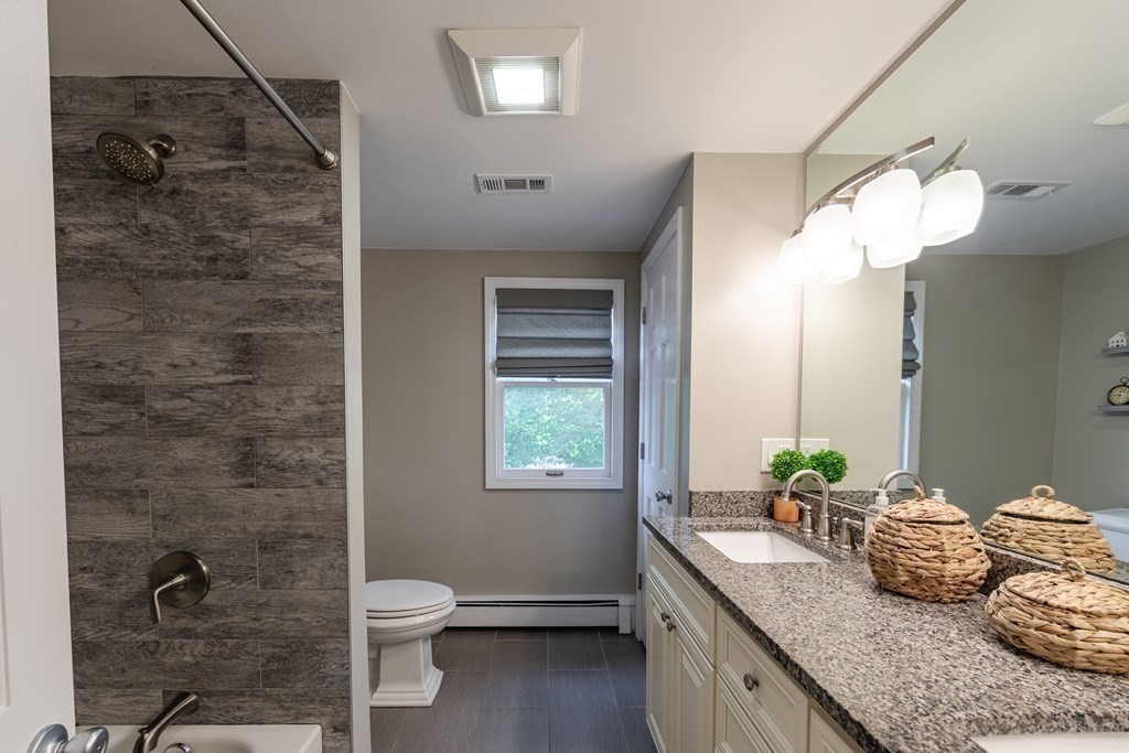 63 Maple Ridge Road Reading, MA 01867 - Photo 30 of 41 a bathroom with a granite countertop sink a toilet and shower