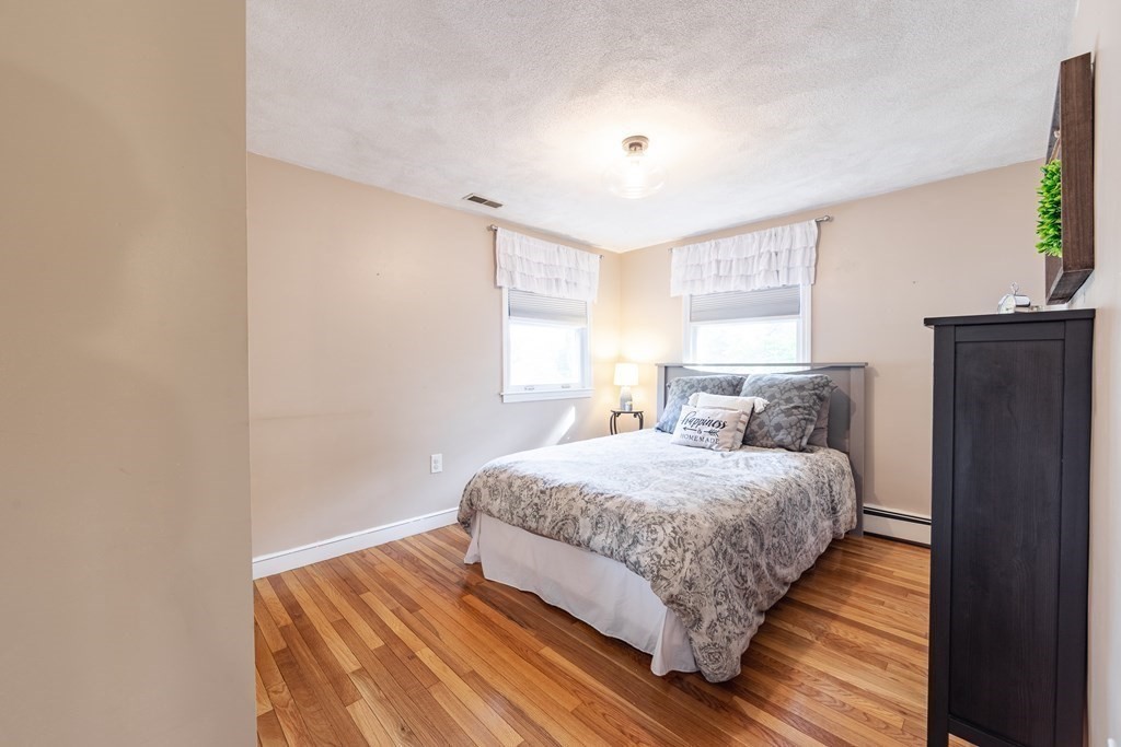 63 Maple Ridge Road Reading, MA 01867 - Photo 32 of 41 a bedroom with bed and wooden floor