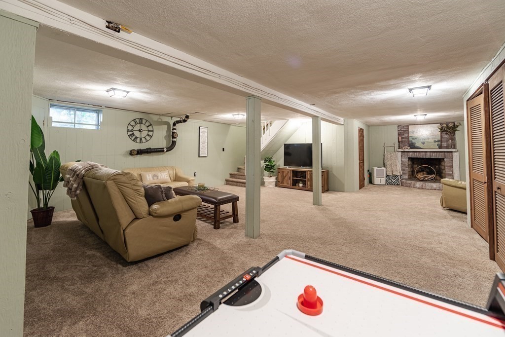 63 Maple Ridge Road Reading, MA 01867 - Photo 34 of 41 a living room with furniture and a flat screen tv