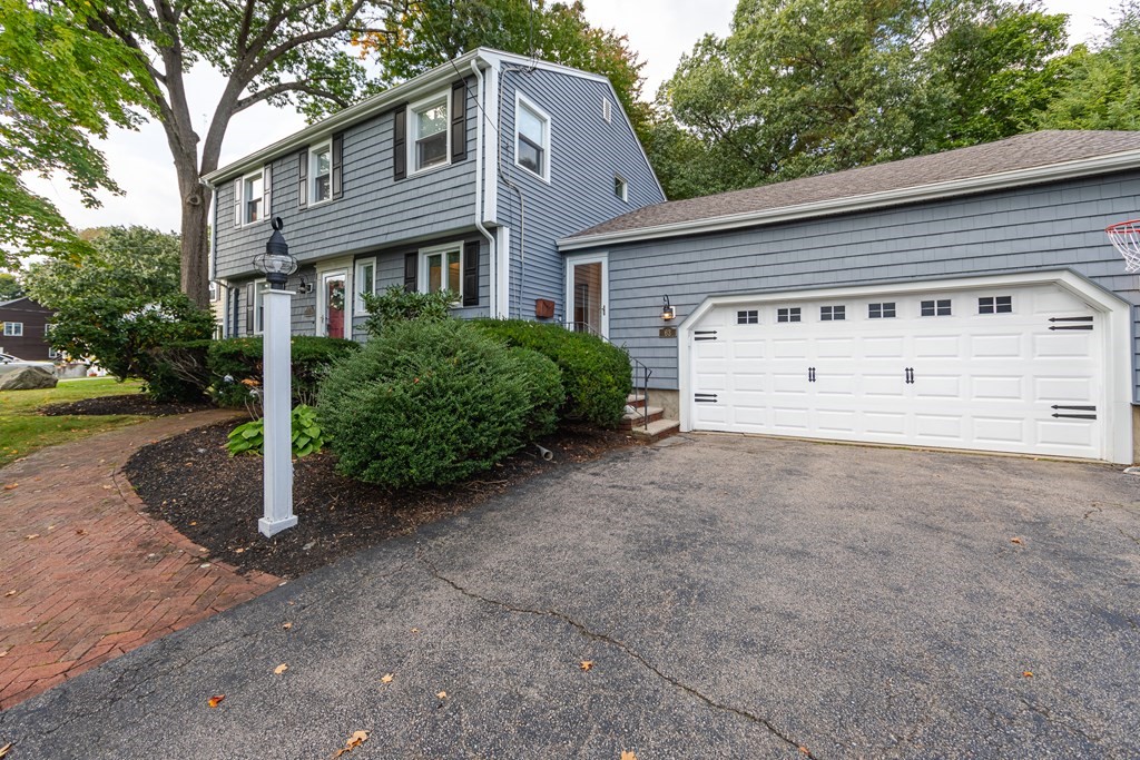 63 Maple Ridge Road Reading, MA 01867 - Photo 5 of 41 a view of a house with a yard and garage