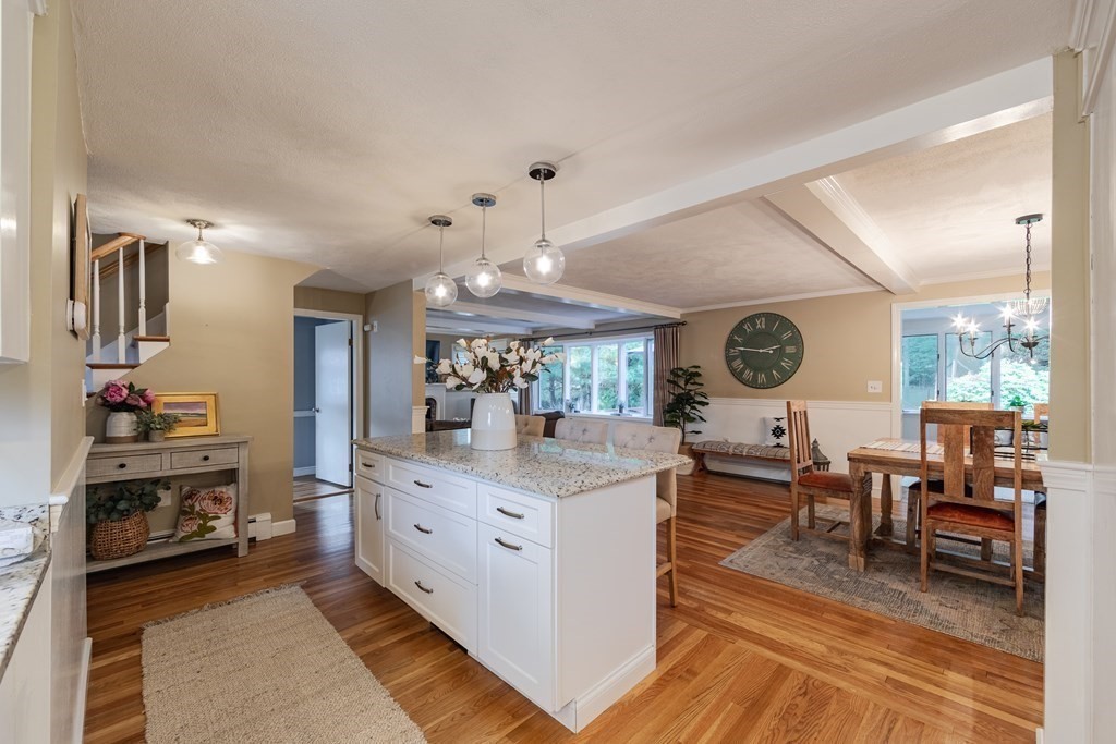 63 Maple Ridge Road Reading, MA 01867 - Photo 6 of 41 a view of a dining room and livingroom with furniture wooden floor a chandelier