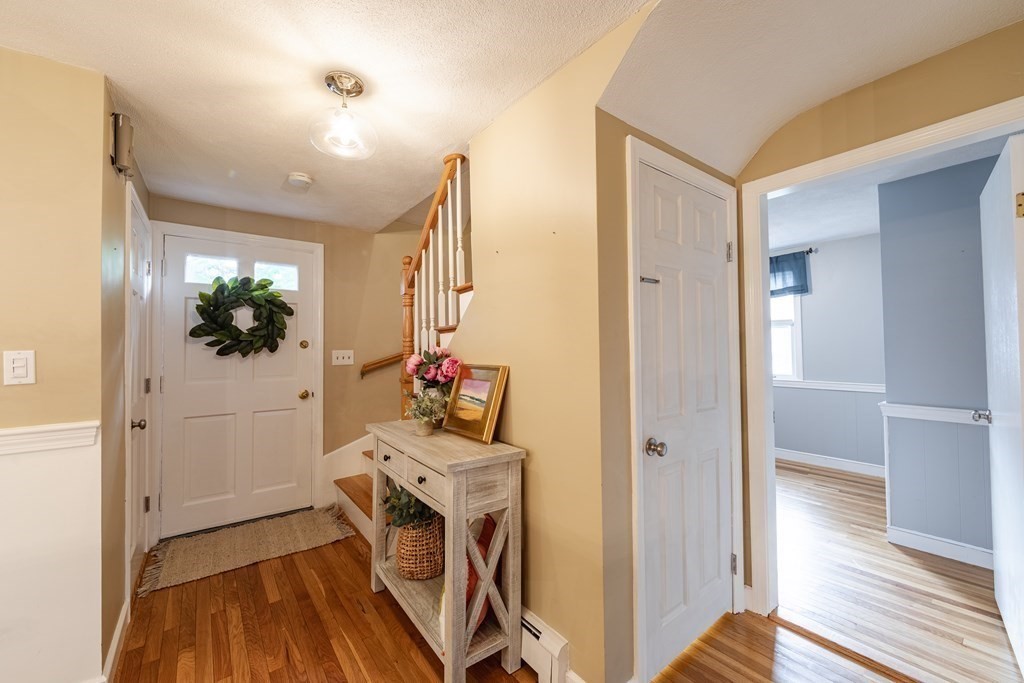 63 Maple Ridge Road Reading, MA 01867 - Photo 9 of 41 a view of a hallway with wooden floor and a living room