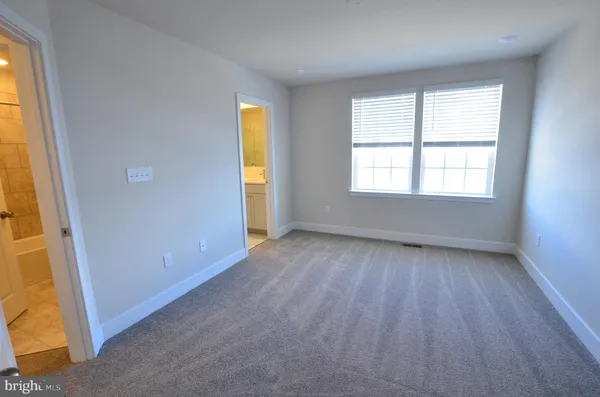 an empty room with a window and wooden floor