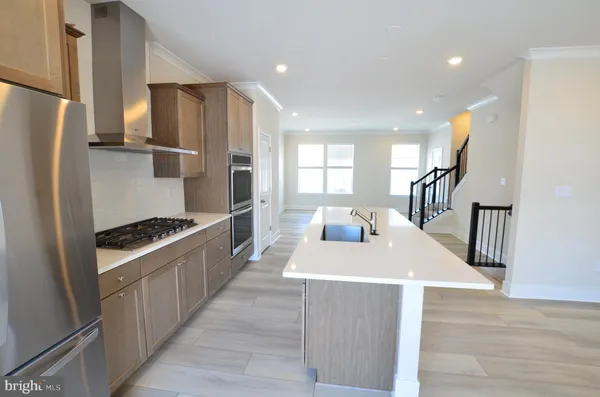 a kitchen with stainless steel appliances granite countertop a refrigerator a stove and a wooden floors