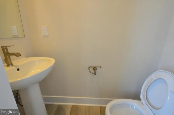 a bathroom with a sink and mirror with toilet