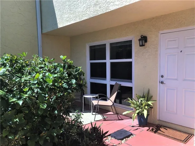 a view of a house with sitting area and potted plants
