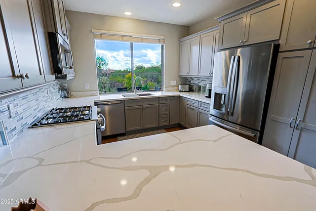 a kitchen with stainless steel appliances a sink stove and refrigerator