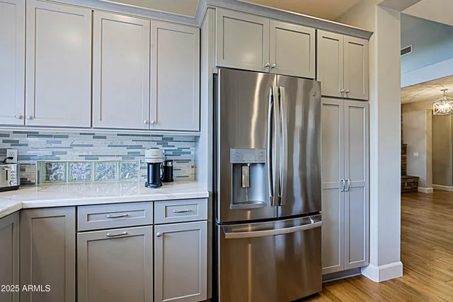 a bedroom with a bed a couch and a flat tv screen on the dresser