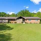 a front view of a house with yard and green space