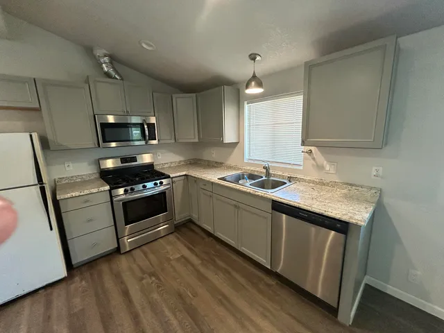 a kitchen with granite countertop a stove a sink and a microwave