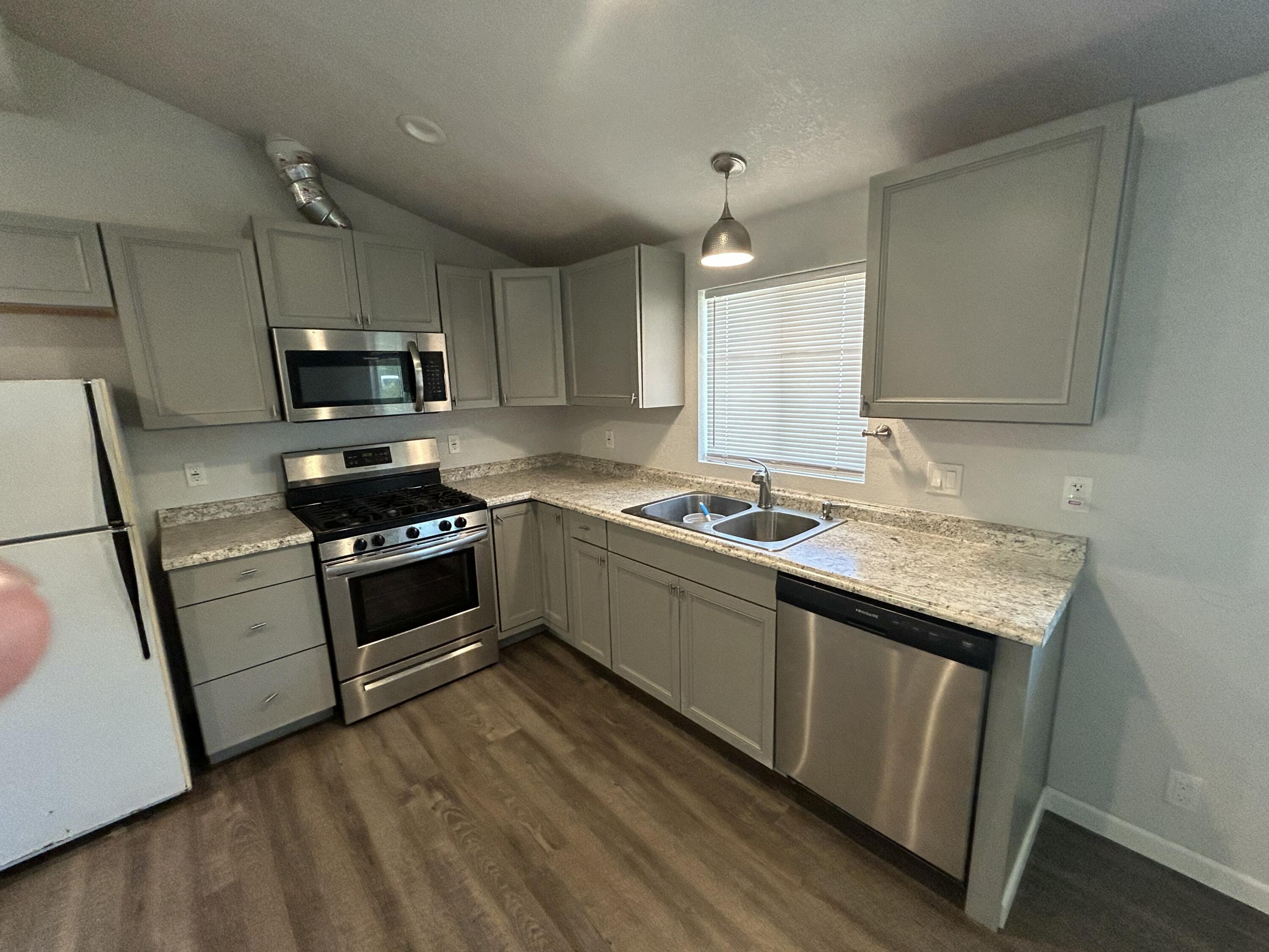 2339 North Drive Redding, CA 96001 - Photo 8 of 18 a kitchen with granite countertop a stove a sink and a microwave
