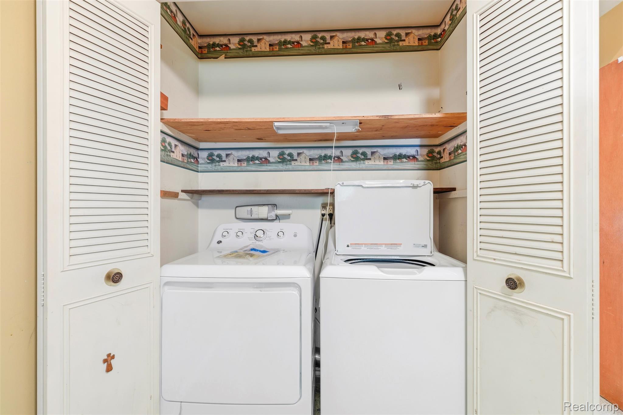 309 Windy Bluff Street Flushing, MI 48433 - Photo 18 of 32 first floor laundry in dedicated laundry closet featuring louvered bi-fold doors, two wood-finish shelves, and integrated lighting