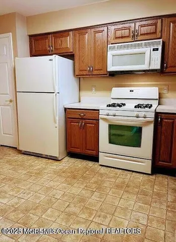 a kitchen with stainless steel appliances granite countertop a stove a refrigerator and a sink