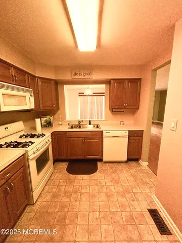 a kitchen with a sink a stove top oven a counter space and a window