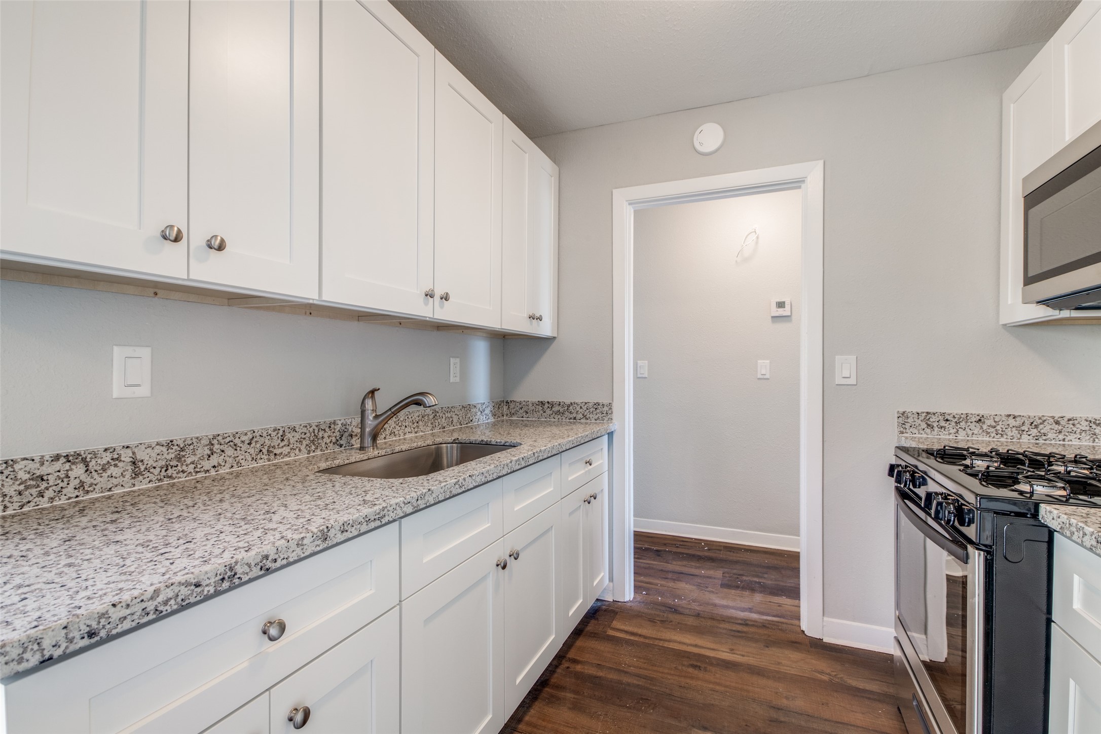 8615 Josie Street Houston, TX 77029 - Photo 11 of 25 a kitchen with granite countertop a sink stove and cabinets