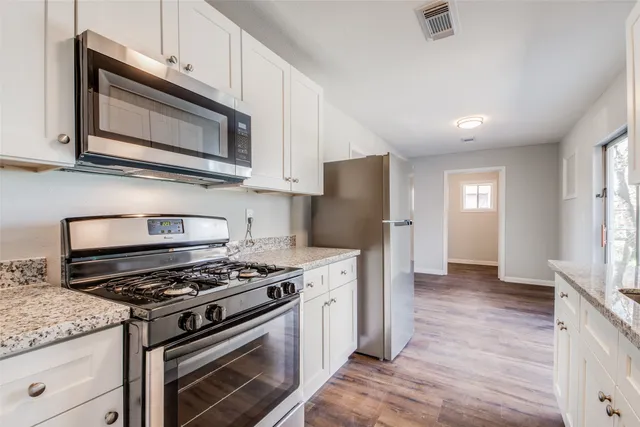 a kitchen with stainless steel appliances granite countertop a stove microwave and refrigerator