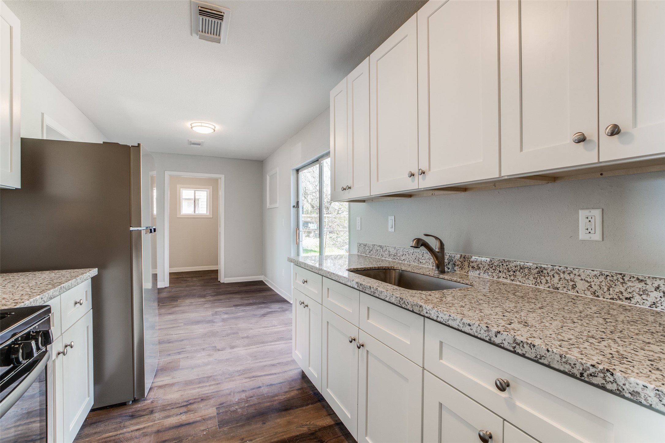 8615 Josie Street Houston, TX 77029 - Photo 14 of 25 a kitchen with granite countertop white cabinets and a sink