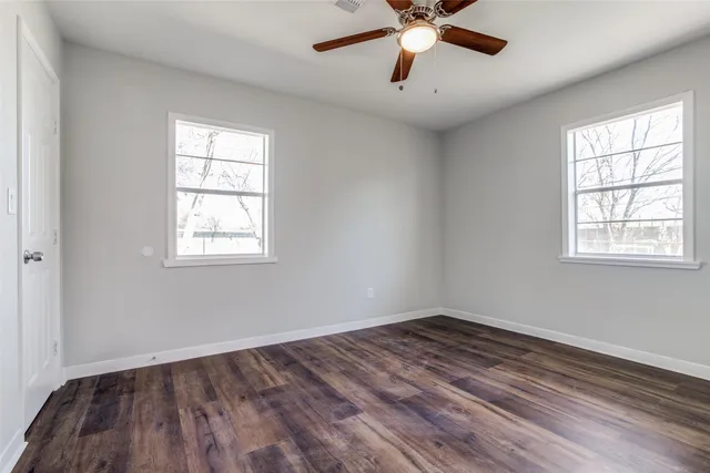an empty room with a window and a fan