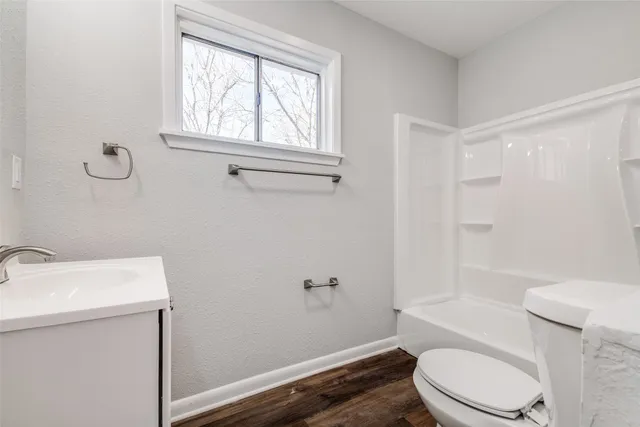 a white toilet sitting next to a bath tub