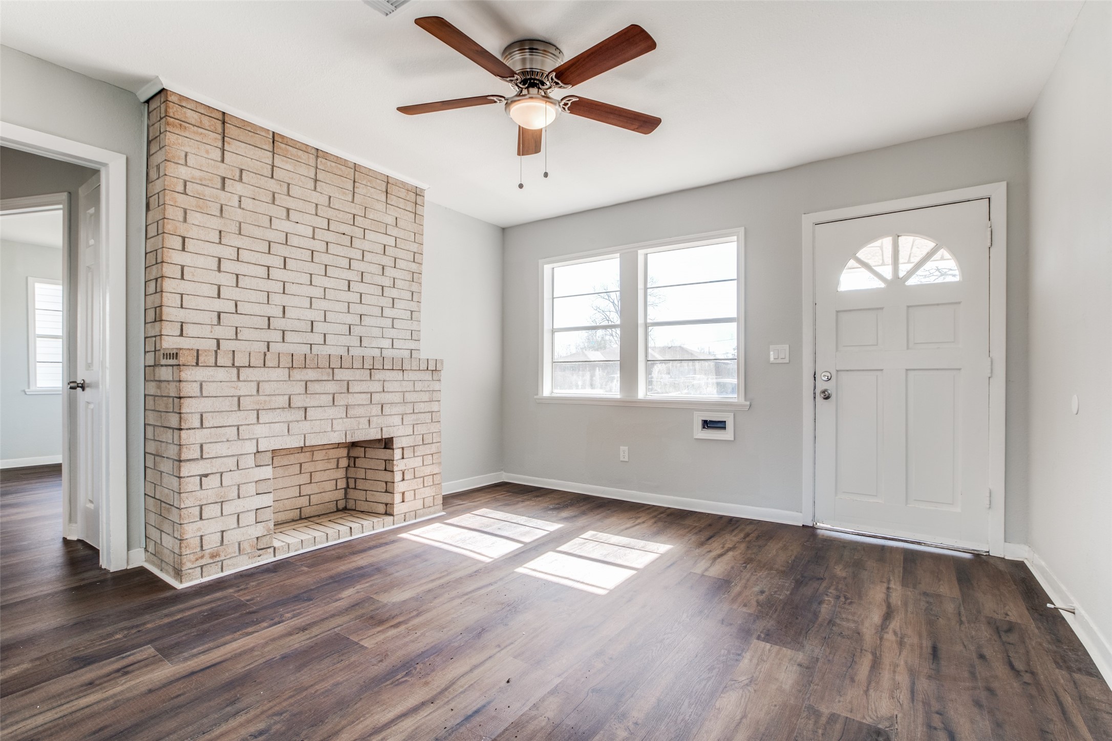 8615 Josie Street Houston, TX 77029 - Photo 4 of 25 an empty room with wooden floor a ceiling fan and windows