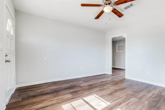 a view of room with a ceiling fan and wooden floor