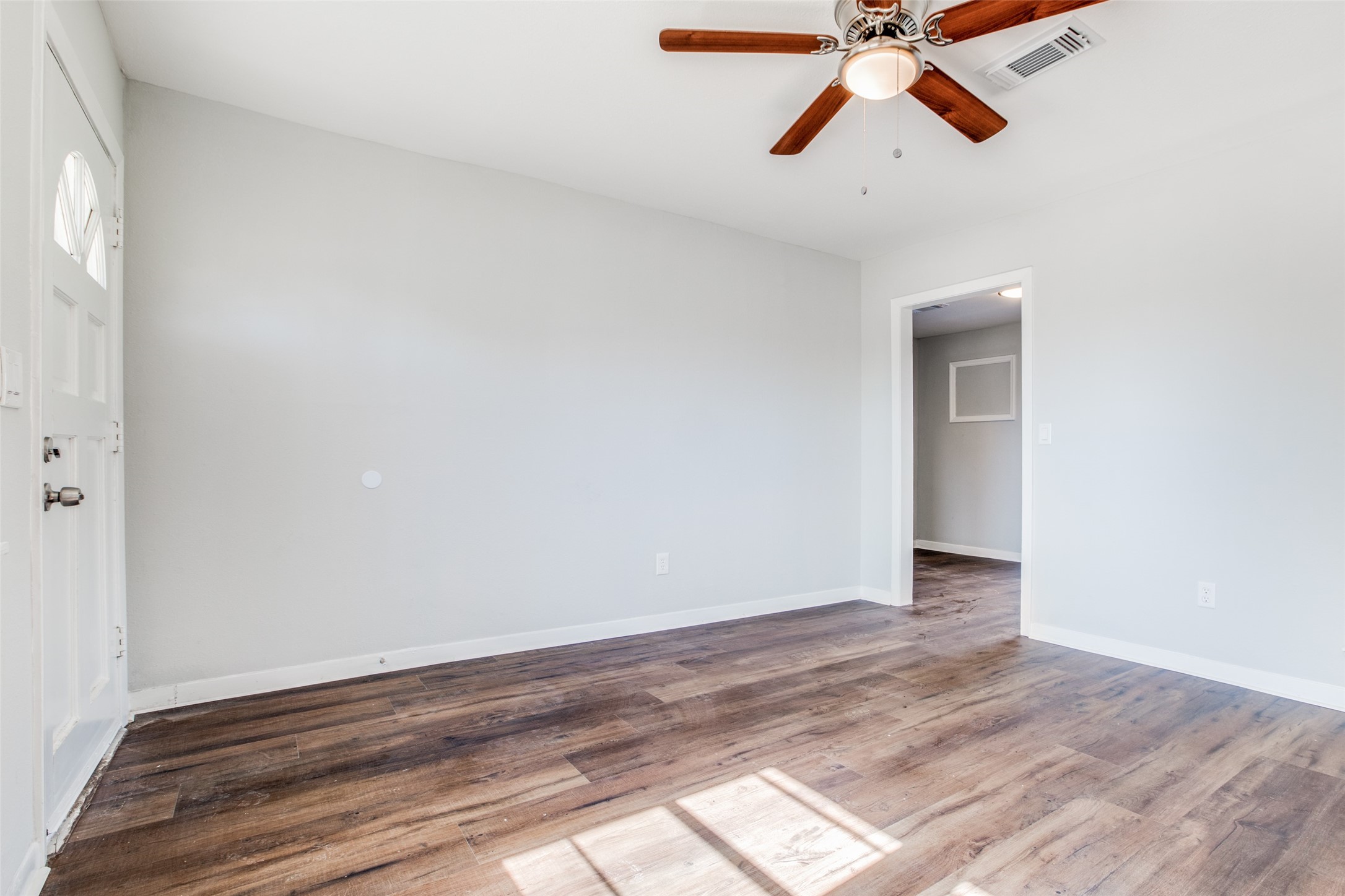 8615 Josie Street Houston, TX 77029 - Photo 6 of 25 a view of room with a ceiling fan and wooden floor