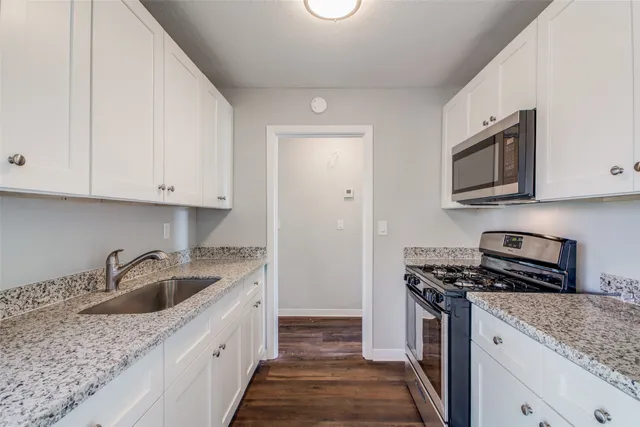 a kitchen with stainless steel appliances granite countertop a sink stove and microwave