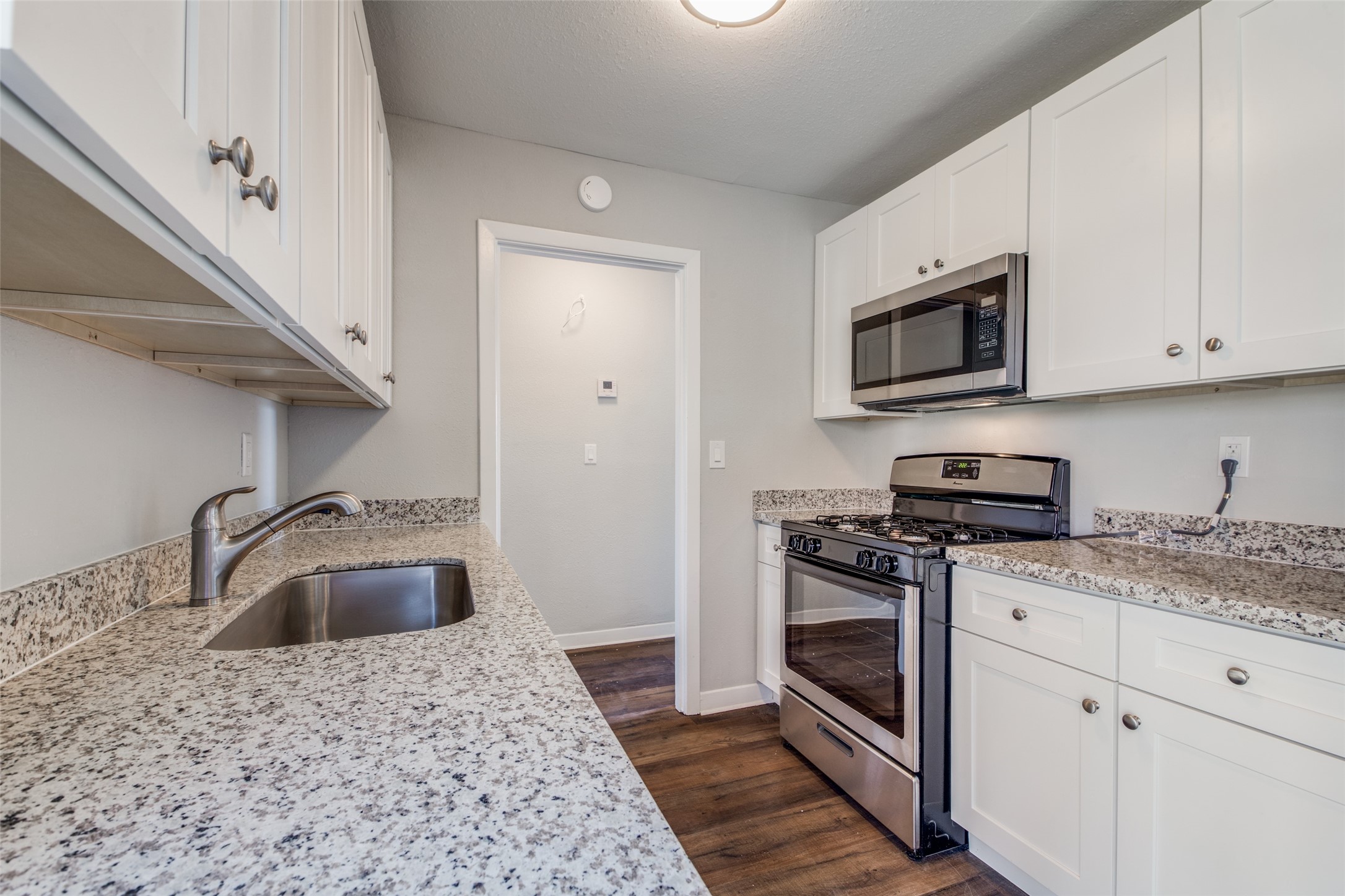 8615 Josie Street Houston, TX 77029 - Photo 10 of 25 a kitchen with granite countertop a sink and stainless steel appliances
