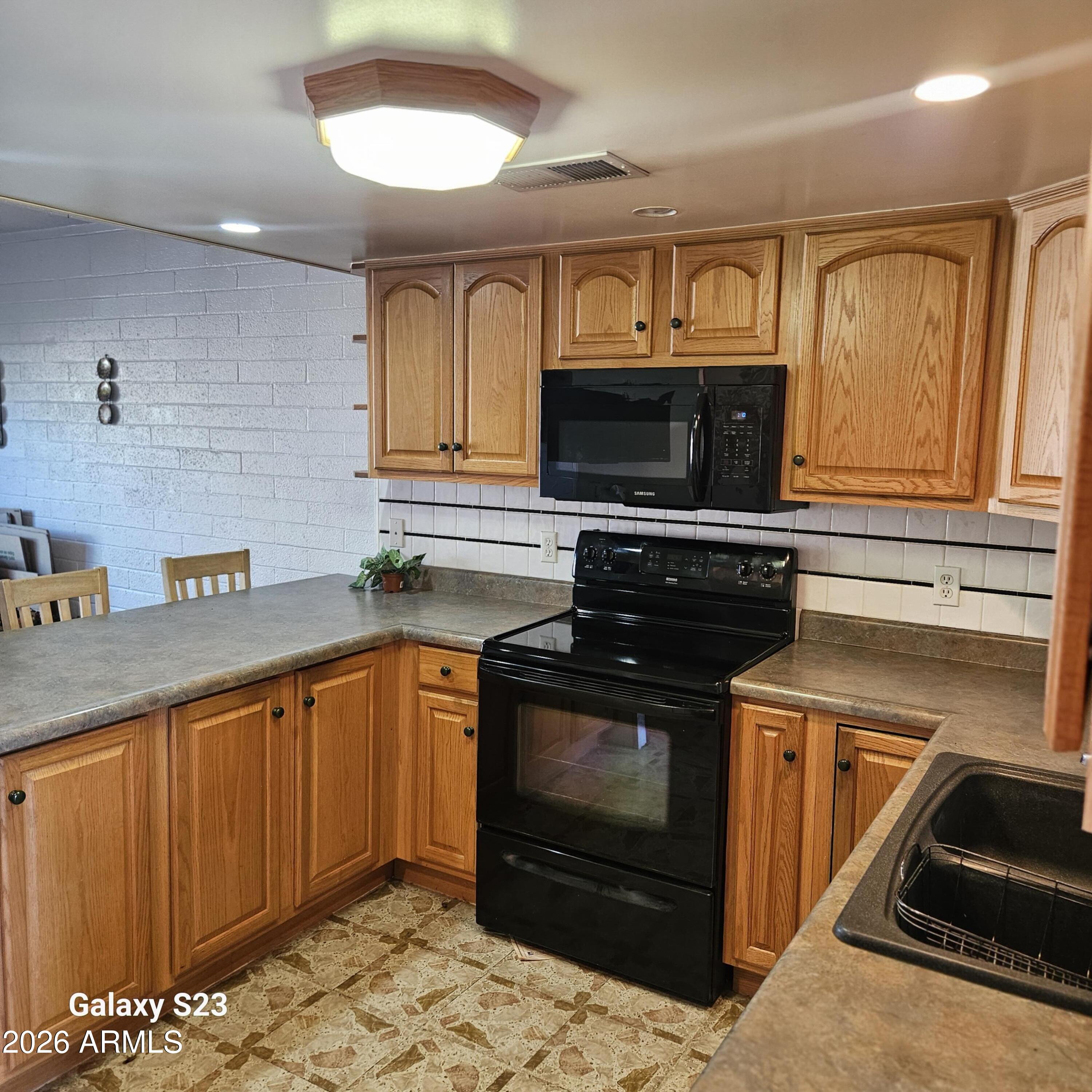 2545 West Rose Lane, Unit A2 Phoenix, AZ 85017 - Photo 2 of 14 a kitchen with granite countertop a stove microwave and sink