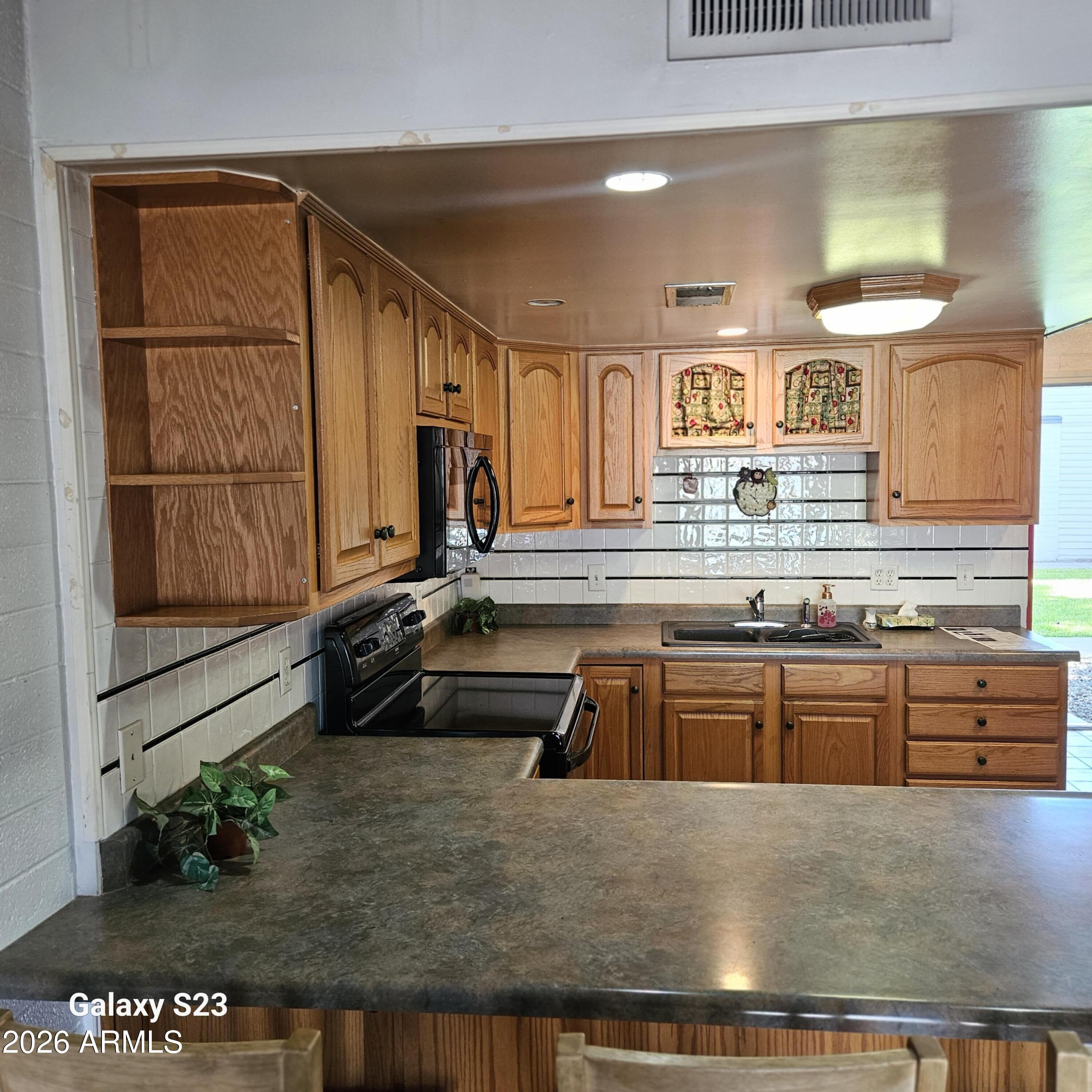 2545 West Rose Lane, Unit A2 Phoenix, AZ 85017 - Photo 3 of 14 a kitchen with stainless steel appliances granite countertop a sink and a stove