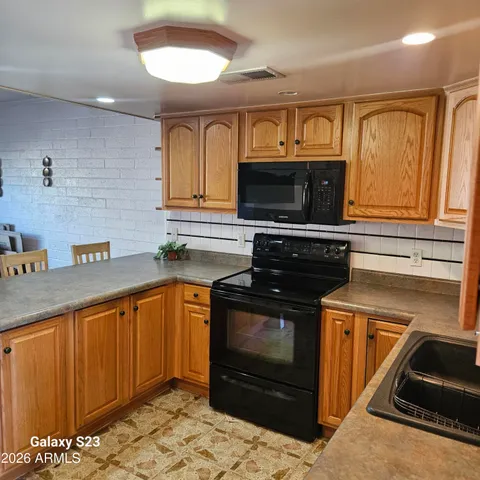 a kitchen with granite countertop a stove microwave and sink