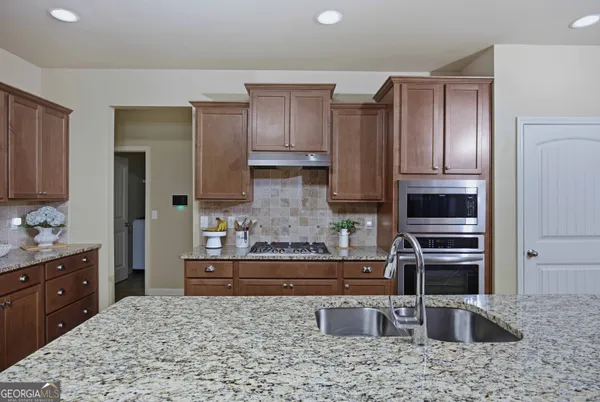 a kitchen with granite countertop stainless steel appliances refrigerator and cabinets