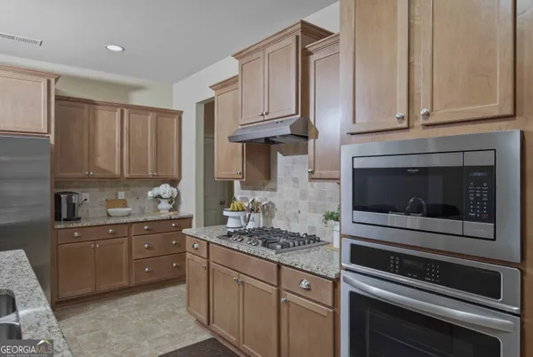 a kitchen with stainless steel appliances granite countertop a sink and a refrigerator