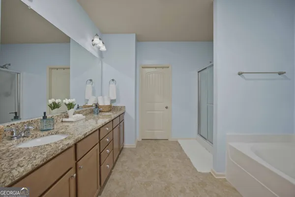 a bathroom with a granite countertop double vanity sink and a mirror