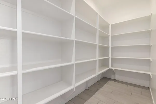 a large kitchen with stainless steel appliances a large counter top and a refrigerator