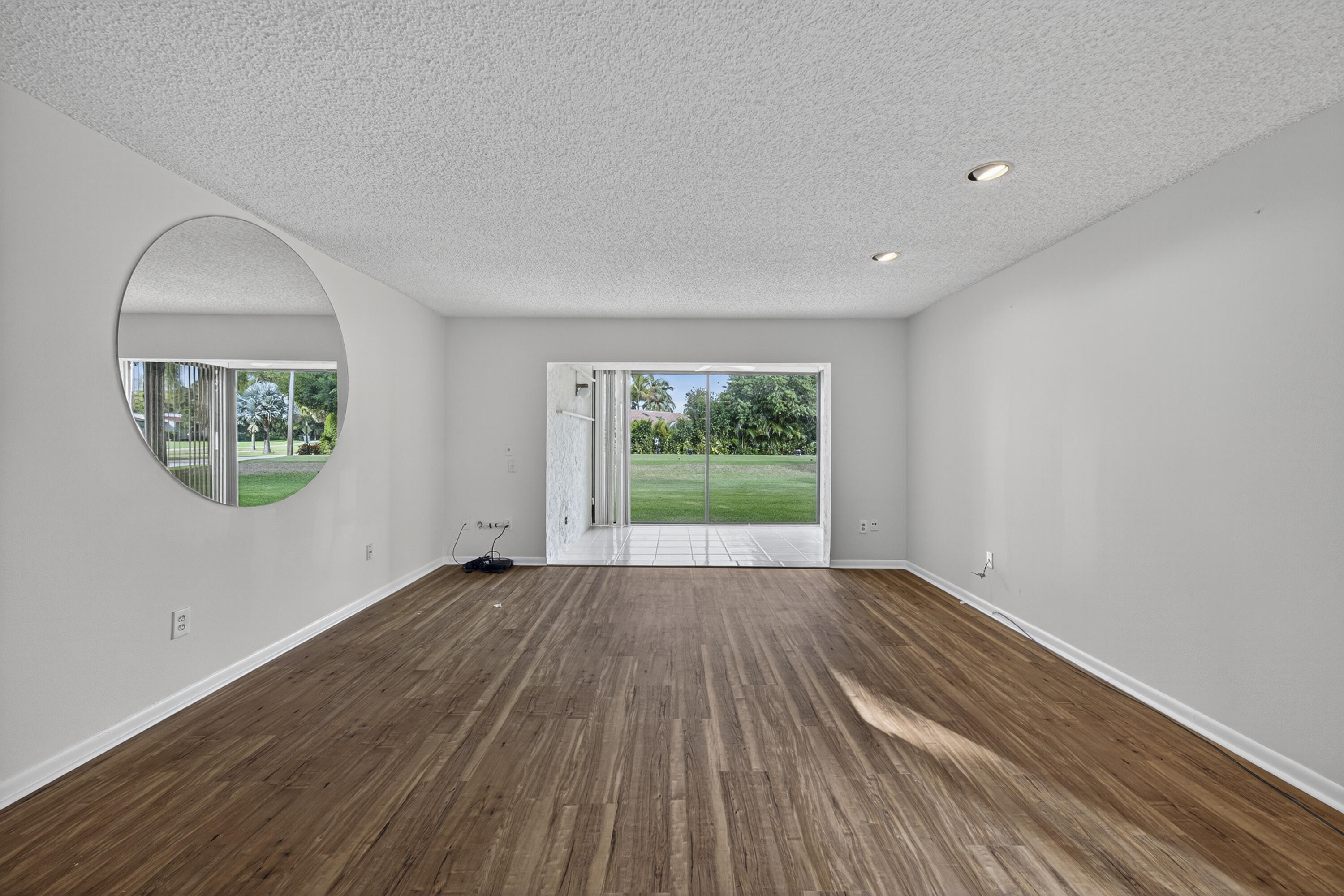 9187 Norte Lago, Unit 5I Boca Raton, FL 33428 - Photo 11 of 37 an empty room with wooden floor and windows