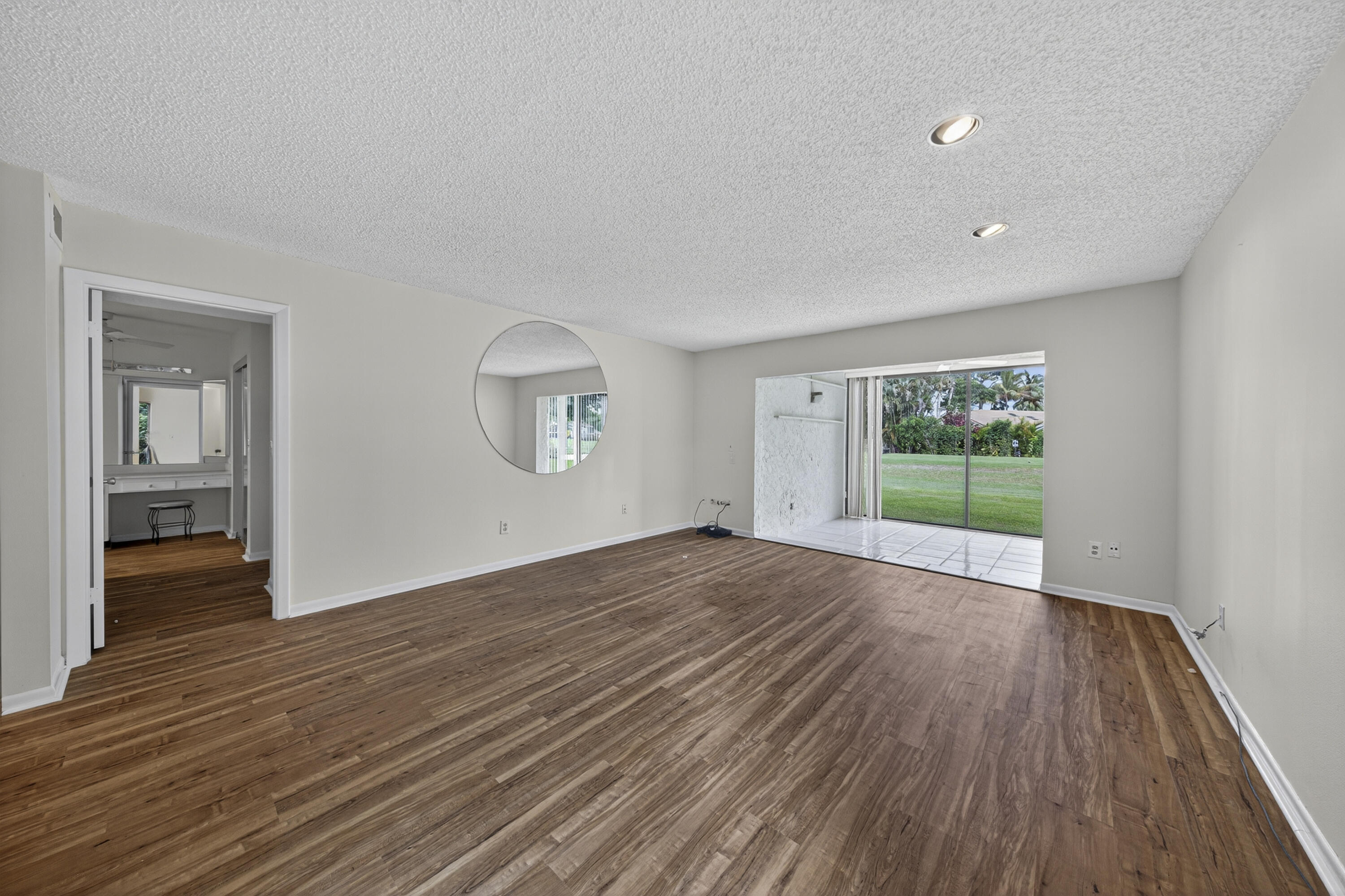 9187 Norte Lago, Unit 5I Boca Raton, FL 33428 - Photo 12 of 37 a view of an empty room with wooden floor and a window