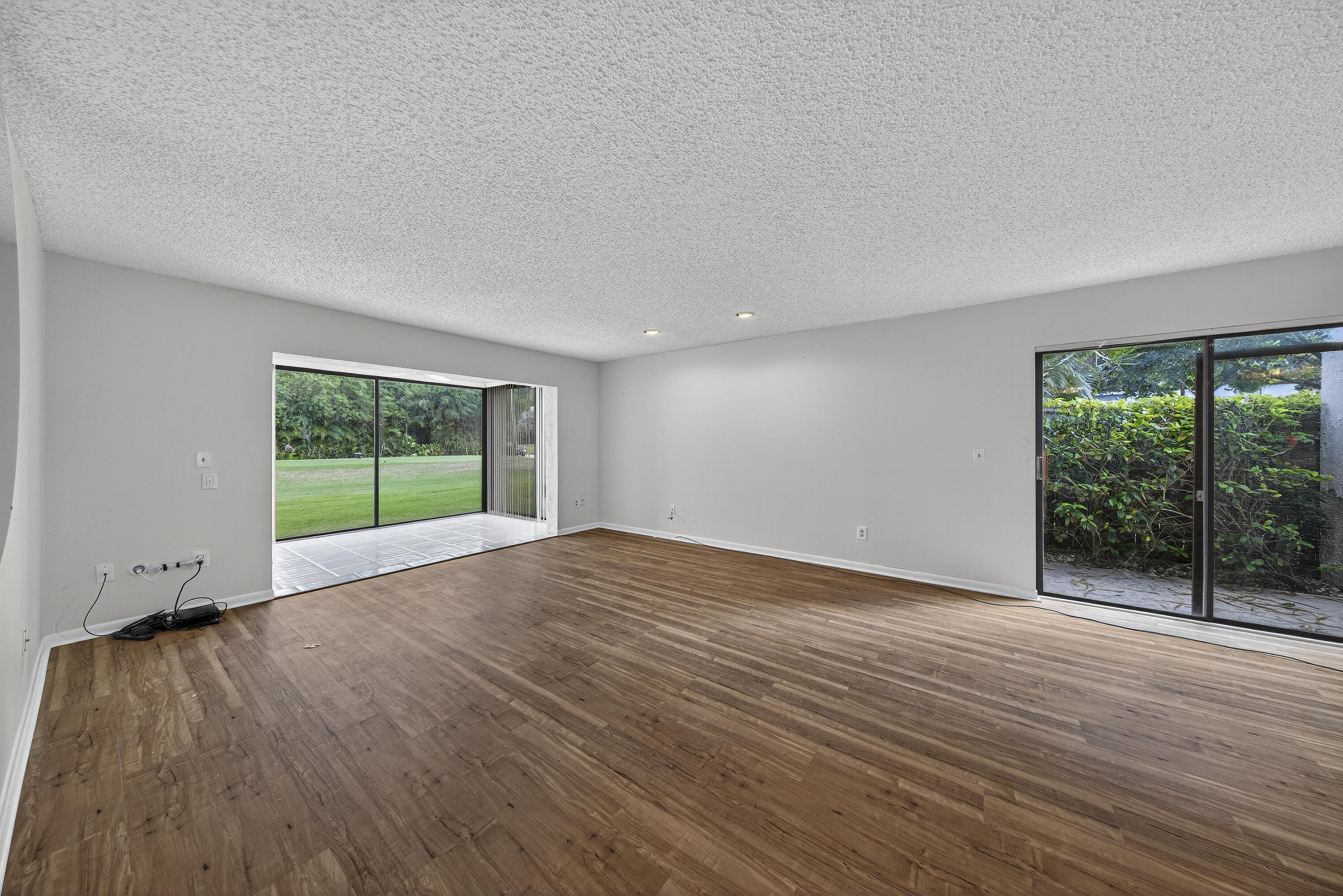 9187 Norte Lago, Unit 5I Boca Raton, FL 33428 - Photo 13 of 37 a view of an empty room with wooden floor and a window