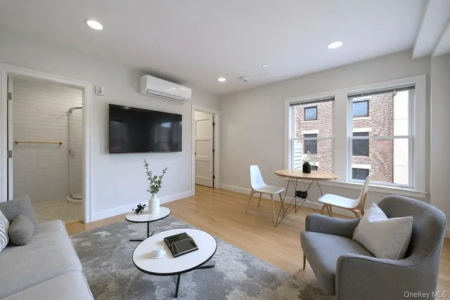 a living room with furniture a rug and a flat screen tv