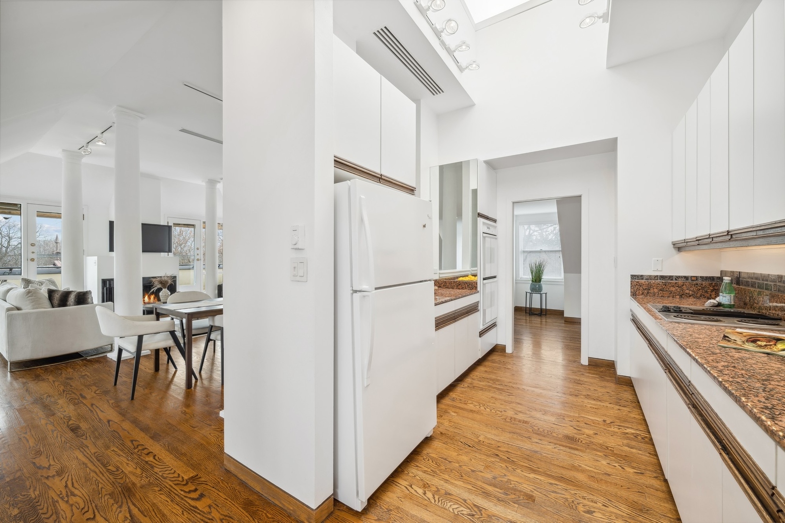 535 North Mayflower Road, Unit D Lake Forest, IL 60045 - Photo 9 of 25 a white kitchen with wooden floor and stainless steel appliances