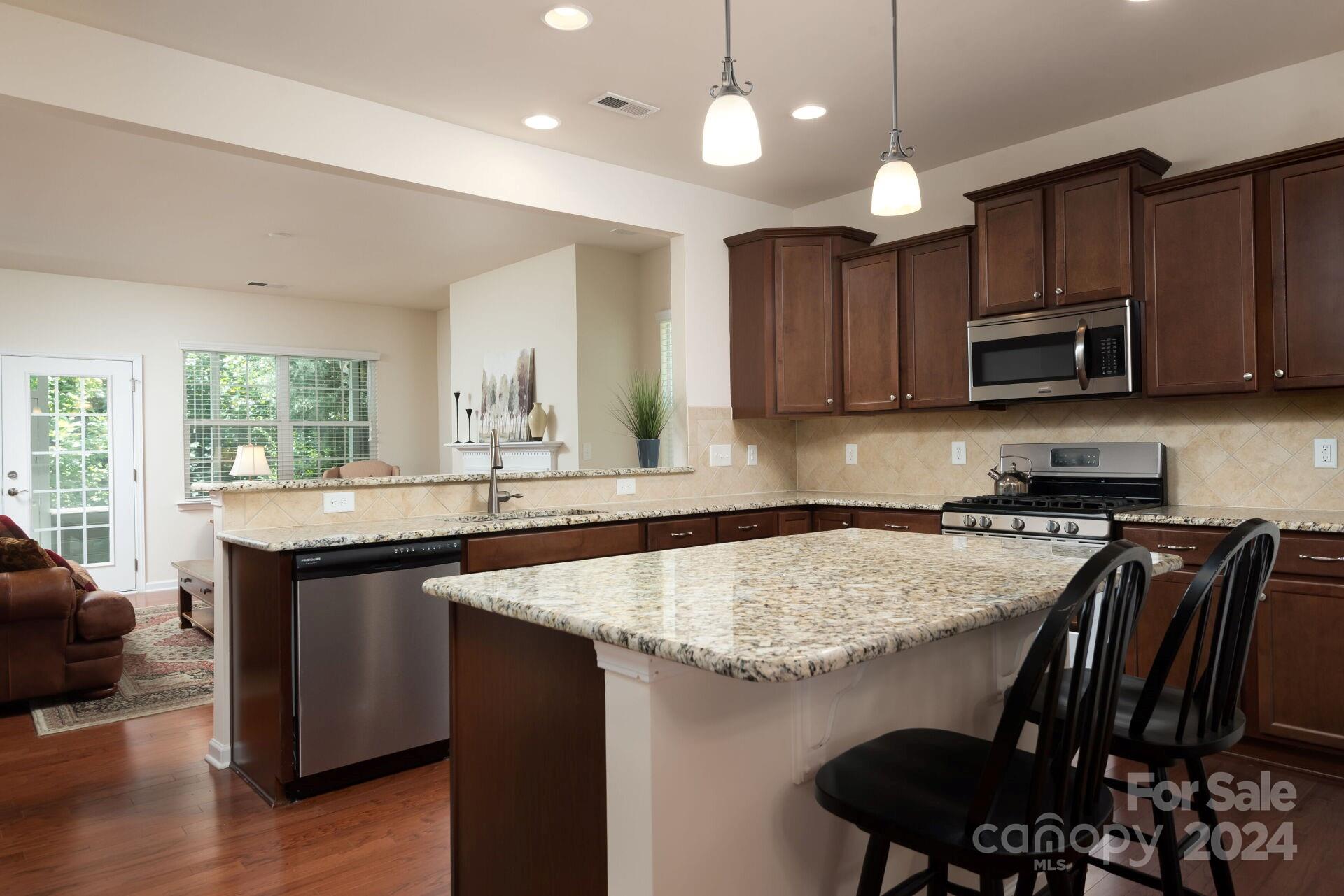 4325 Perth Road Indian Land, SC 29707 - Photo 5 of 33 a kitchen with stainless steel appliances granite countertop a stove a sink a microwave a center island and furniture