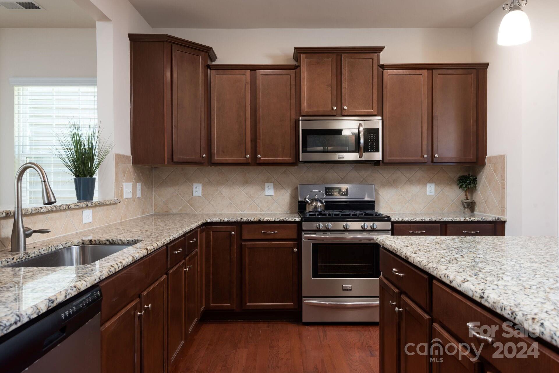 4325 Perth Road Indian Land, SC 29707 - Photo 8 of 33 a kitchen with granite countertop a sink a stove and cabinets