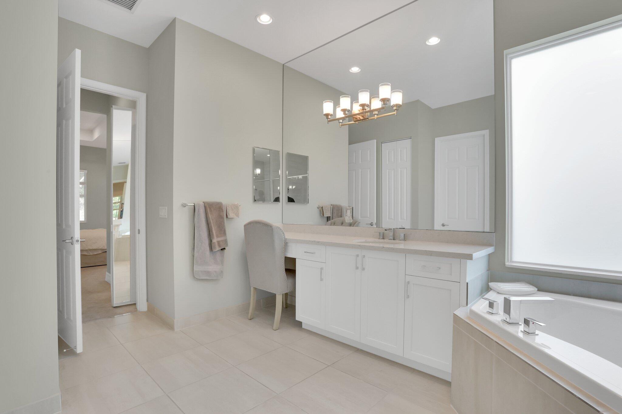 8203 Arabian Range Road Boynton Beach, FL 33473 - Photo 26 of 50 a bathroom with a double vanity sink a mirror a bathtub and shower