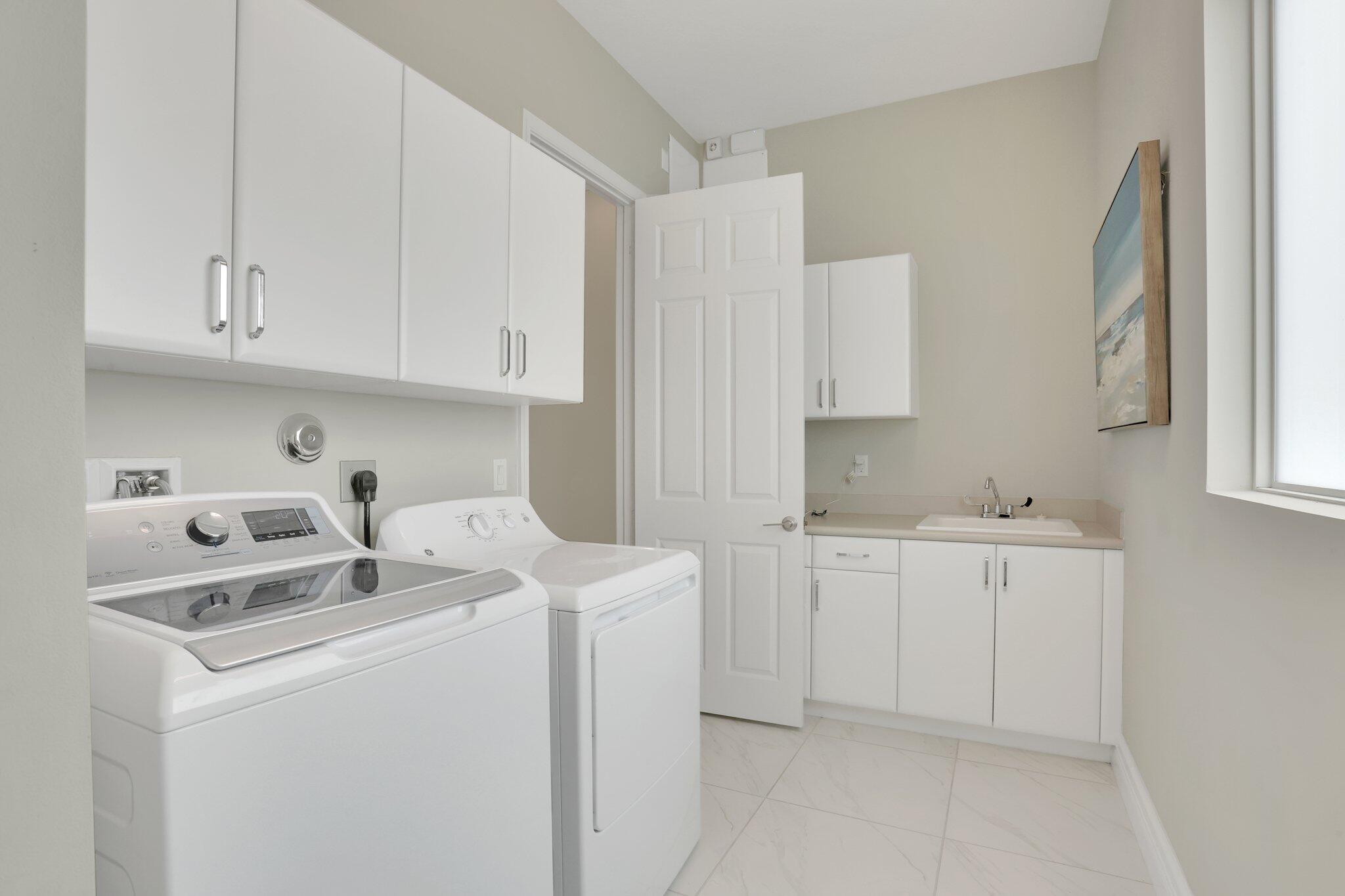 8203 Arabian Range Road Boynton Beach, FL 33473 - Photo 27 of 50 a utility room with cabinets washer and dryer