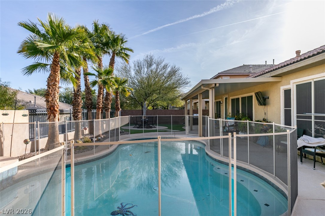 7524 Midnight Rambler Street Las Vegas, NV 89149 - Photo 46 of 51 A private backyard oasis features a fenced swimming pool and covered patio for optimal outdoor enjoyment.