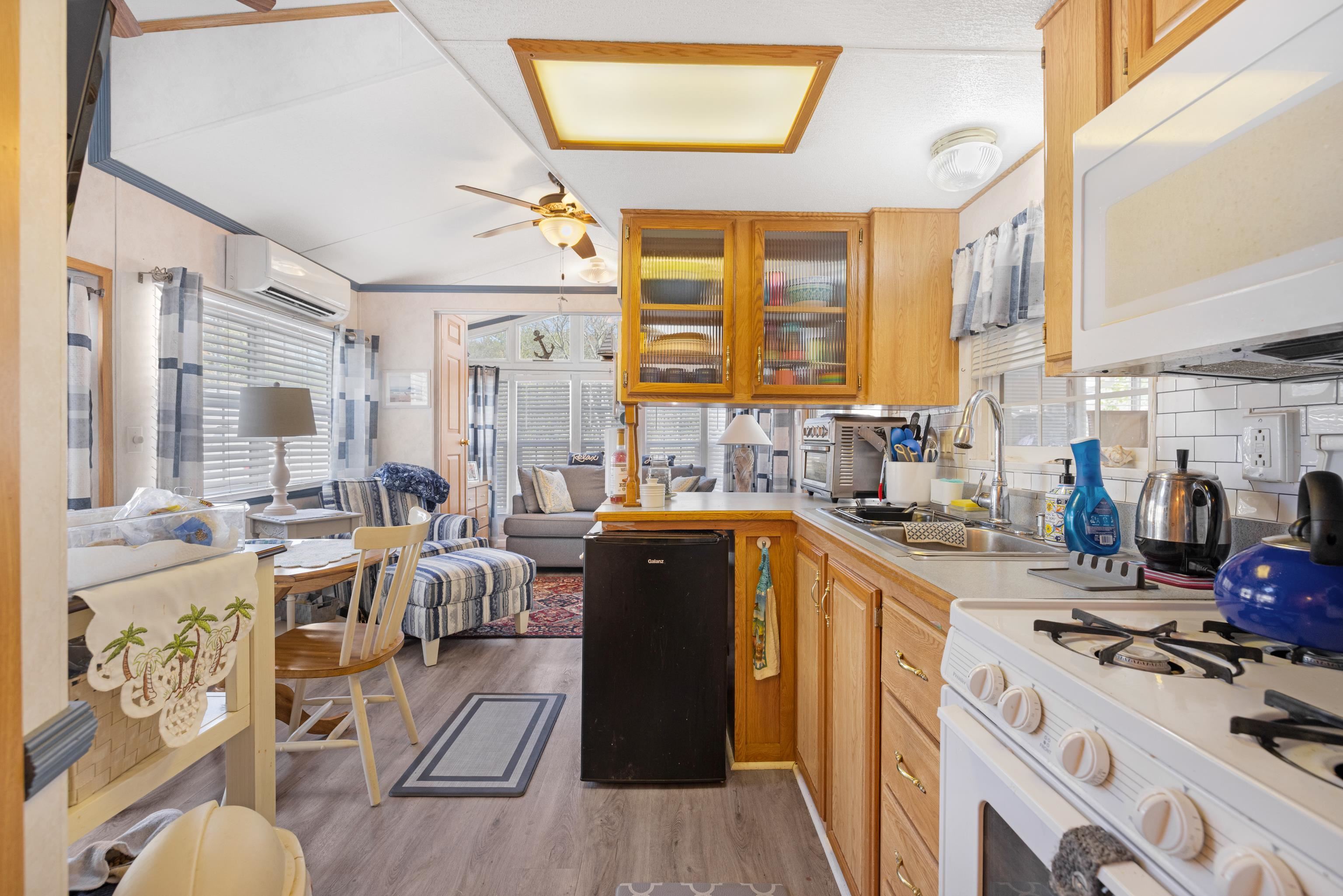709 Rt 9 S, Unit 384 Cape May, NJ 08204 - Photo 8 of 22 a kitchen with stainless steel appliances a stove a sink dishwasher a refrigerator white cabinets and wooden floor