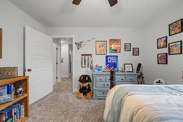 a bedroom with a bed a book shelf and a shelf