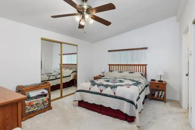 a spacious bedroom with a bed and a chandelier