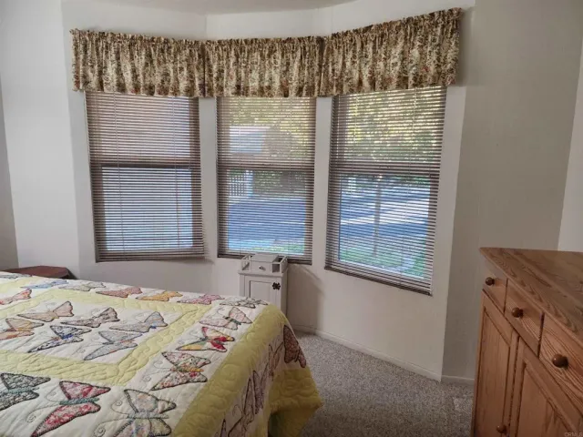 a bed sitting in a bedroom next to a window